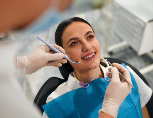 Snow-white smile of a female patient with braces on examination by a dentist in a dental clinic with modern equipment. Dental care and dentistry.